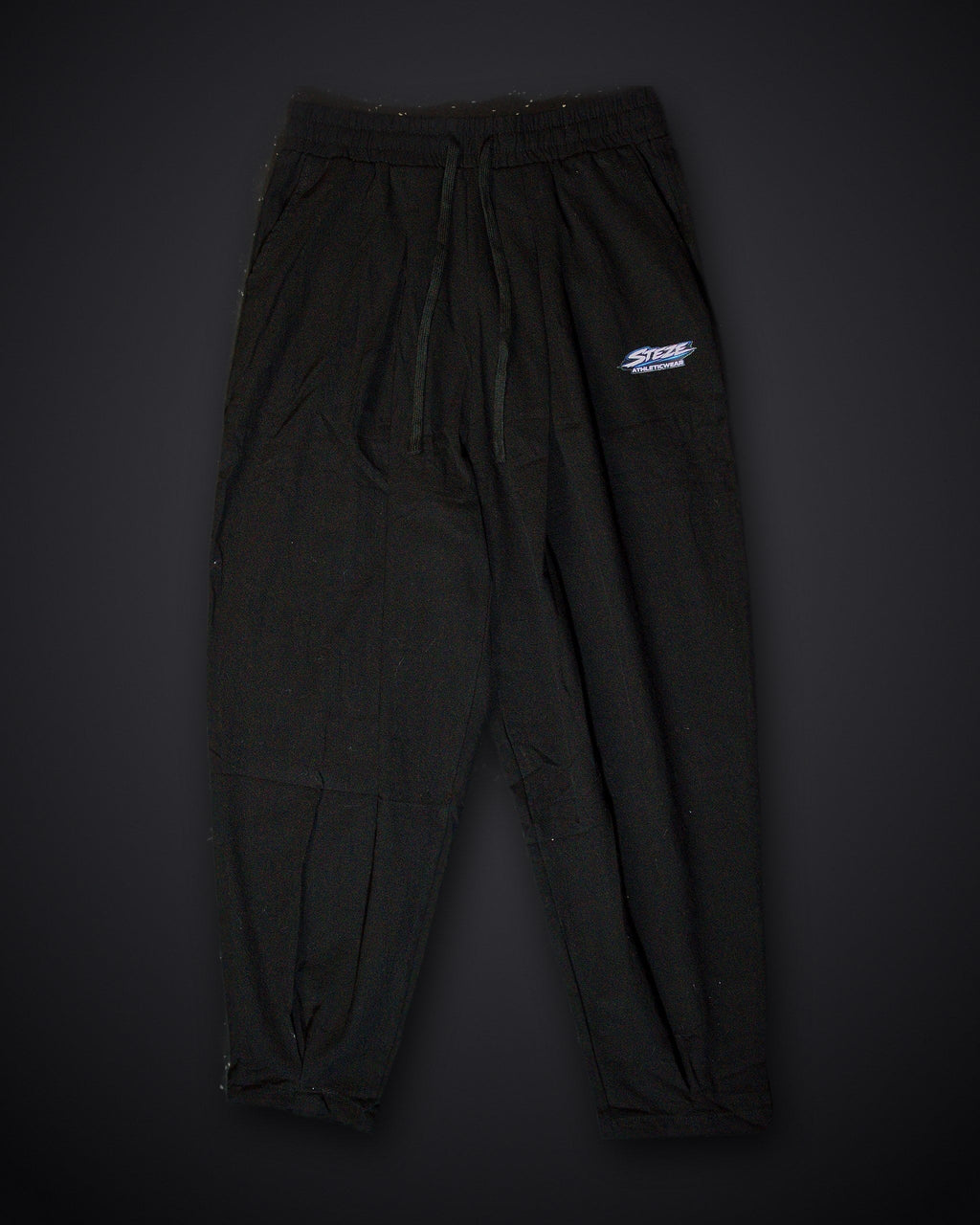 STEZE Linen Pant in black, flat lay on dark studio background