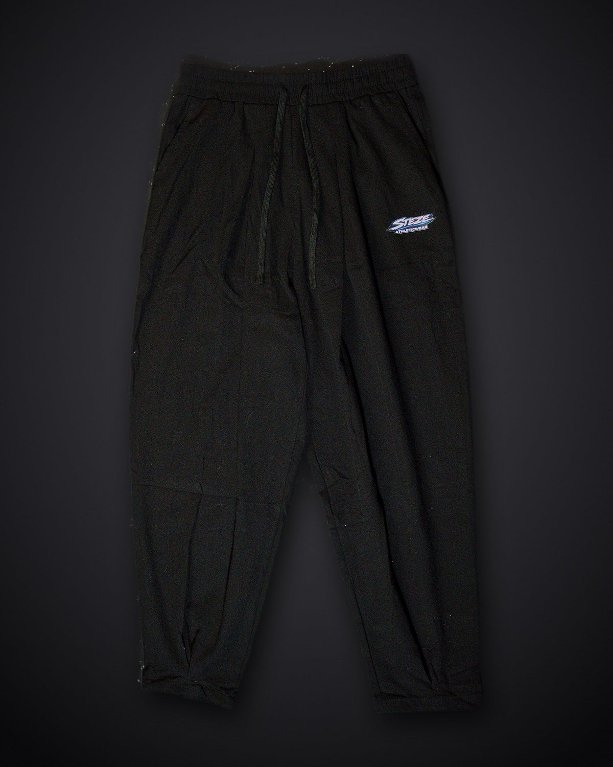 STEZE Linen Pant in black, flat lay on dark studio background