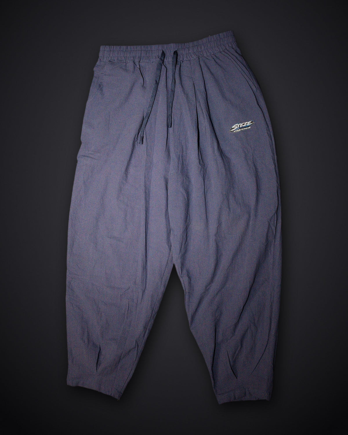 STEZE Linen Pant in navy, flat lay on dark studio background