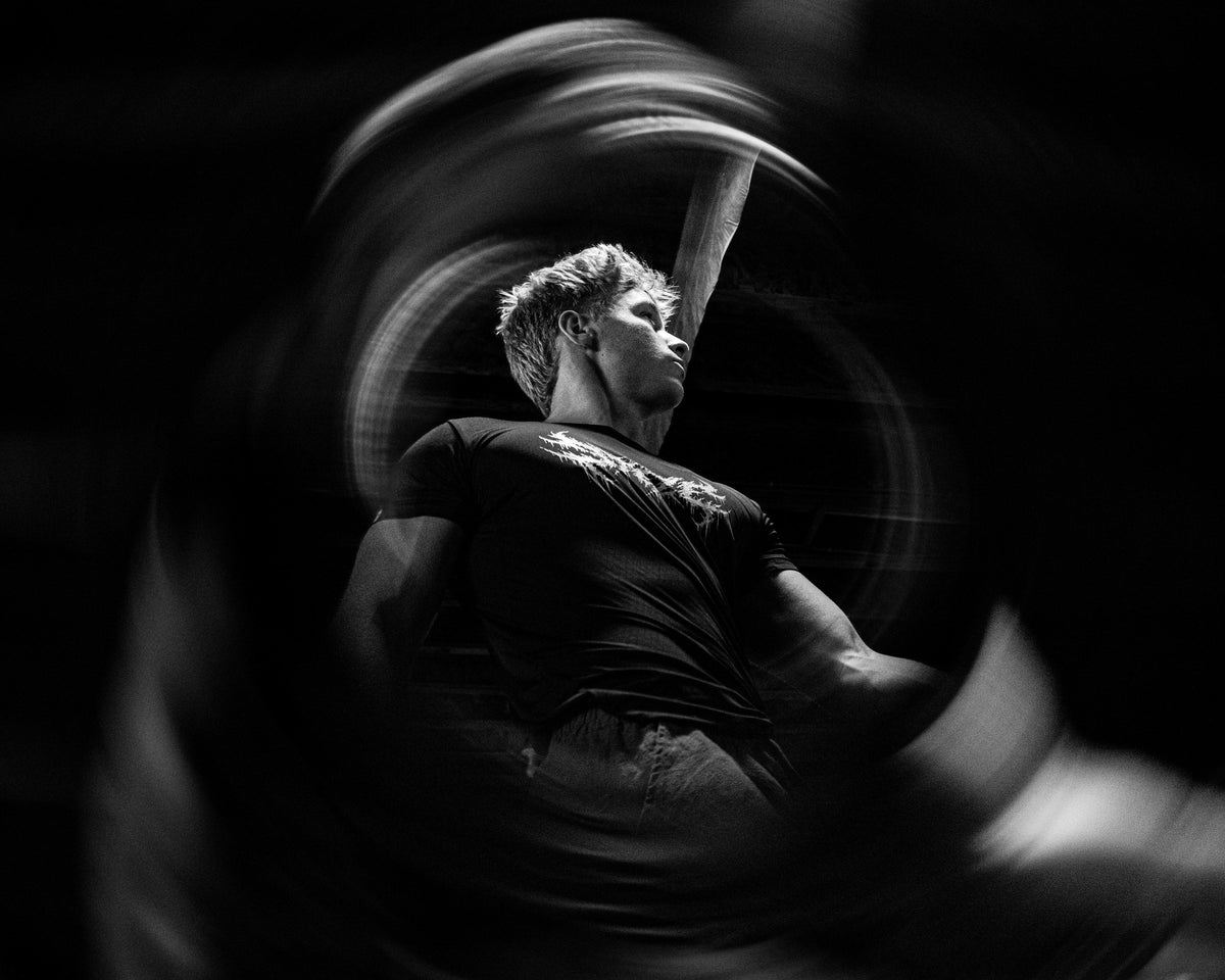 STEZE Compression Tee worn during training, black and white light-trail shot